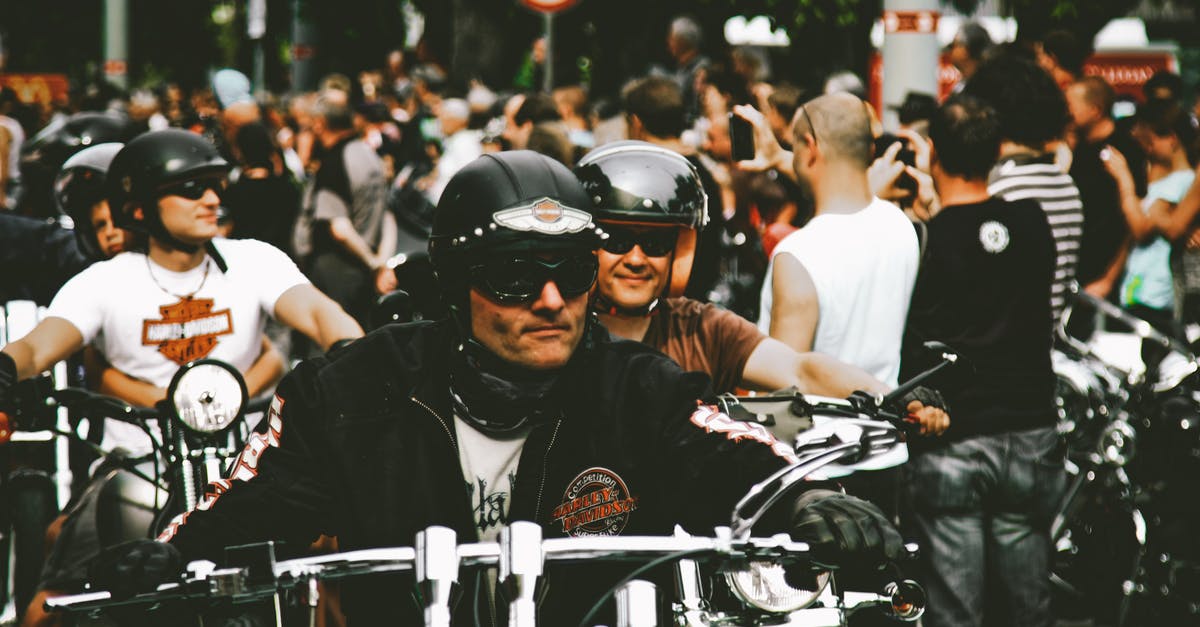 A man riding a motorcycle in front of a crowd